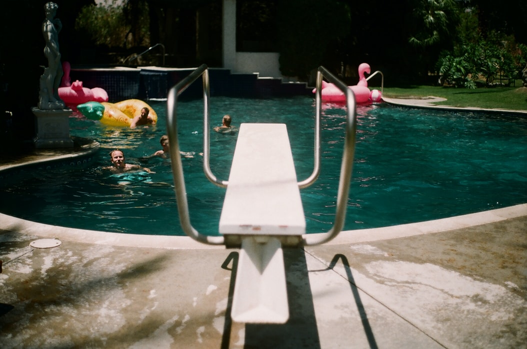 a diving board in a backyard pool