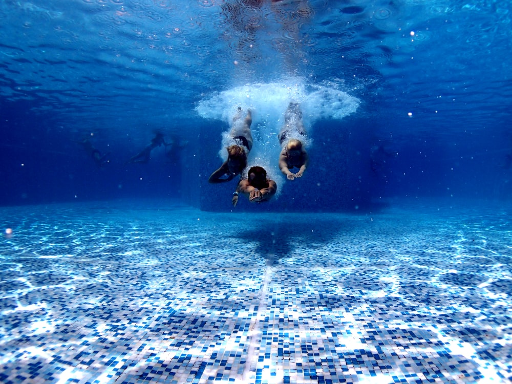 people diving in a pool with appropriate depth as defined by the govt.