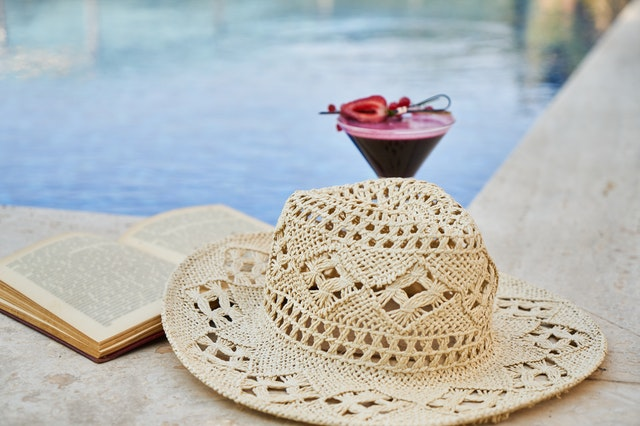 A hat and a Book near pool