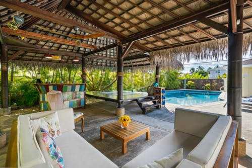 An outdoor living space with furniture and a pool.