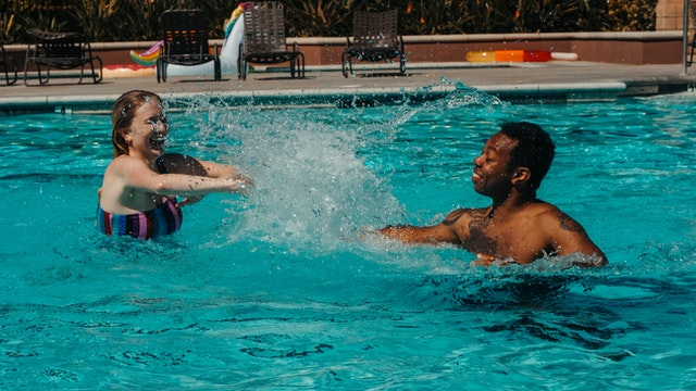 two people splashing water on each other