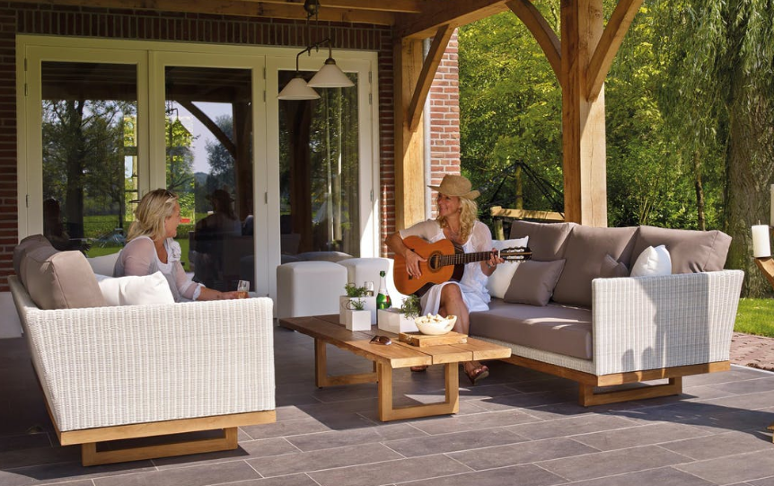 Two women sitting on outdoor sofas