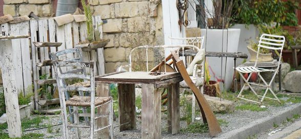 The picture shows broken furniture on a sidewalk after a storm 