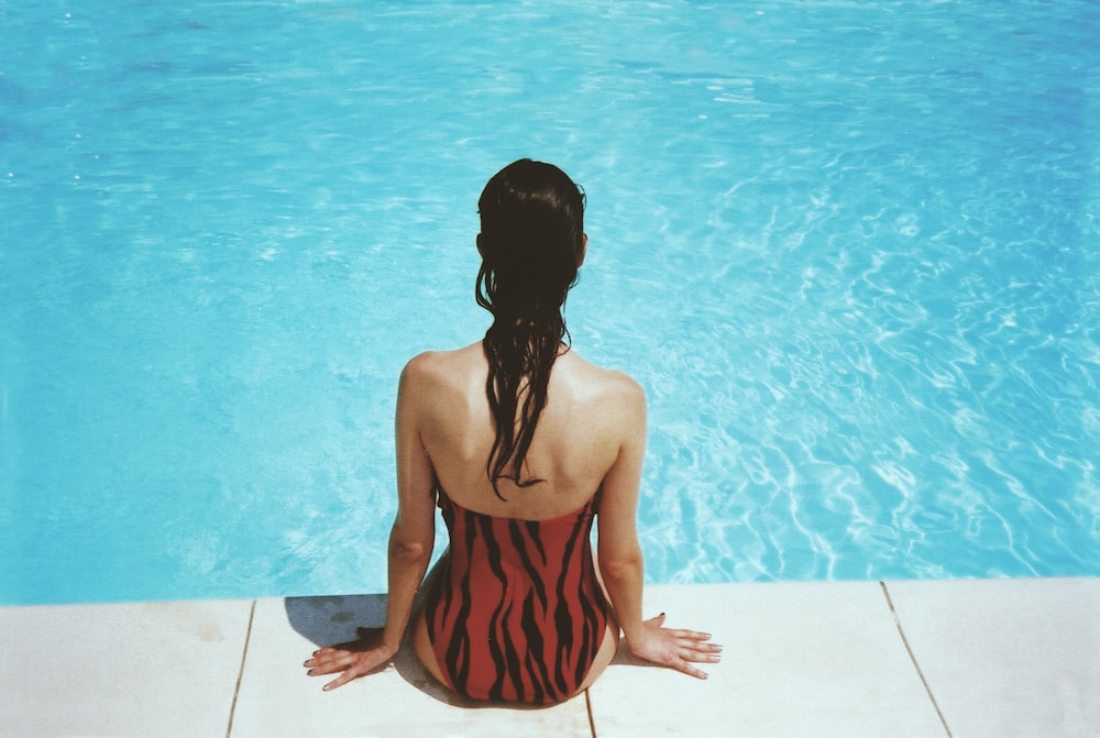 A woman relaxing near a swimming pool