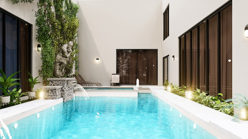 A gorgeous indoor pool area with lighting and water features 