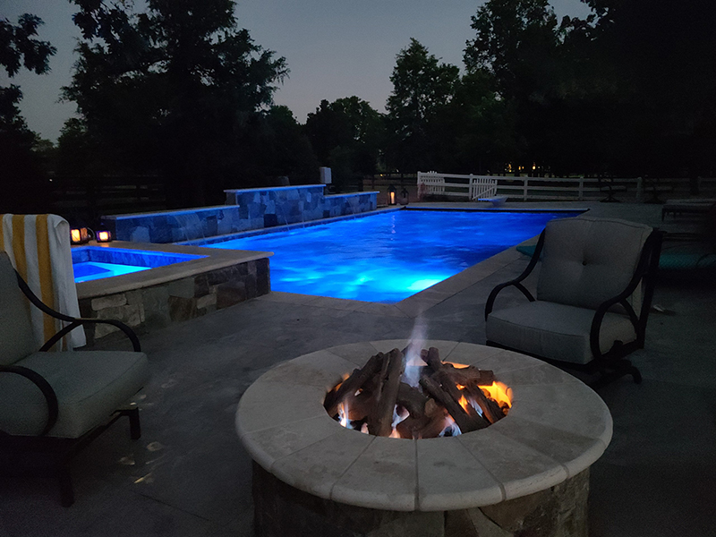 An outdoor living space in Sterling with a fire pit and a pool.