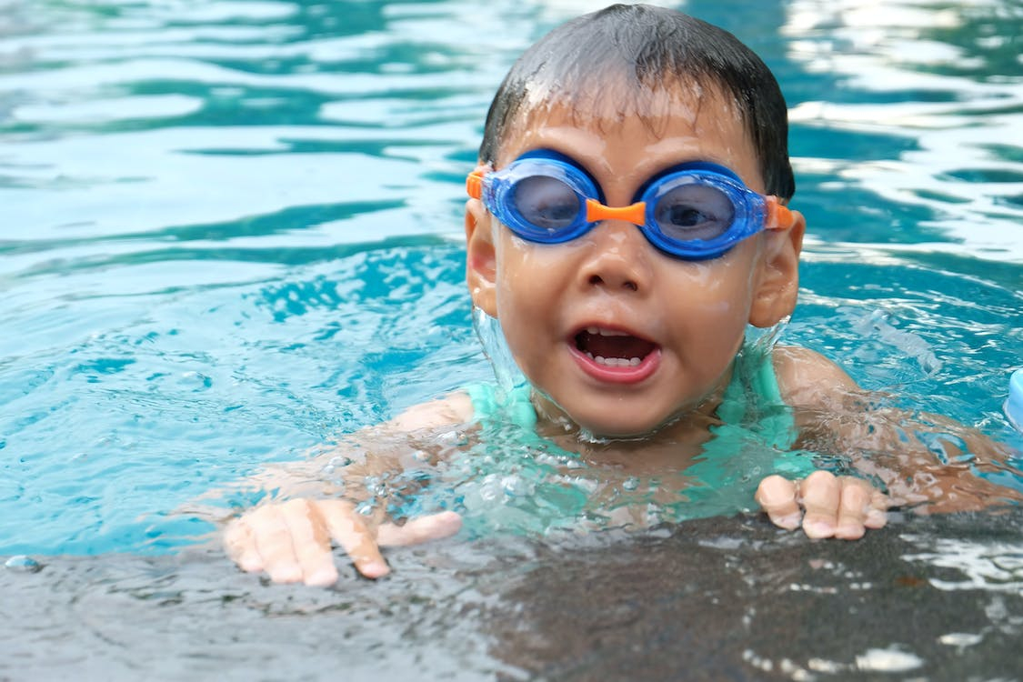 A Child Swimming In A Pool